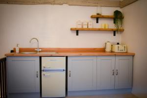 una cucina con un bancone con un lavello e un frigorifero di The Gate Cottage a Thaxted Altre 9 foto