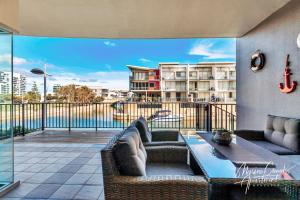 a patio with two couches and a table on a balcony at Marina Canals Apartment in Mandurah