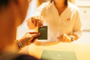 a woman holding up a card with her hands at Hotel Kirchenwirt in Kaunertal