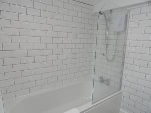 a white bathroom with a shower and a tub at Victoria House - 3 Bedrooms, 3 Bathrooms by Cliftonvalley Apartments in Bristol