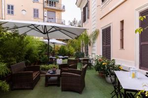 an outdoor patio with chairs and an umbrella at Hotel Coppede' in Rome