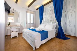 a white bedroom with blue curtains and a bed at Luxury Rhodes Villa Diamond Villa Hot Tub Beautiful Terrace 3 Bdr Lindos in Líndos