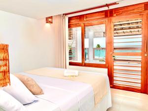 1 dormitorio con cama y ventana en Windtown Beach Hotel en Cumbuco