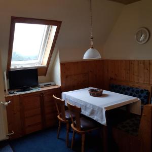 ein Esszimmer mit einem weißen Tisch und einem Fenster in der Unterkunft Ferienwohnung Heinrich in Kurort Altenberg
