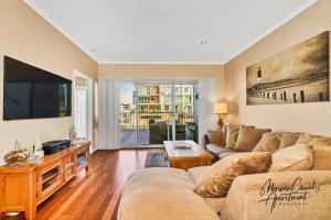 a living room with a couch and a tv at Marina Canals Apartment in Mandurah