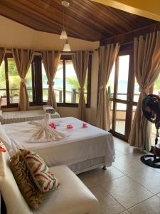 ein Schlafzimmer mit einem Bett und einer Couch und Fenstern in der Unterkunft Guesthouse Saint Tropez in Arraial do Cabo + 102 Fotos