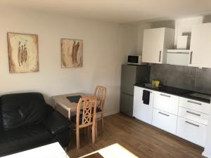 a living room with a couch and a kitchen at Apartment am Kurpark in Bad Oeynhausen