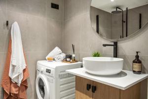 a bathroom with a washing machine and a sink at BJØRVIKA APARTMENTS, Teaterplassen, Oslo city center in Oslo