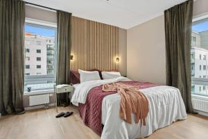 a bedroom with a large bed and a large window at BJØRVIKA APARTMENTS, Teaterplassen, Oslo city center in Oslo