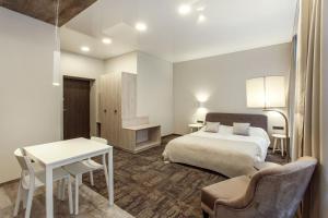 ヴィリニュスにあるOld Town Trio Apartmentsのベッドとデスクが備わるホテルルームです。