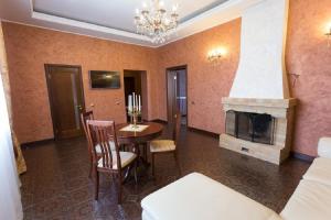 a living room with a table and a fireplace at Hotel in Ecopark Razdolye in Omsk