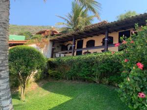 ein Haus mit einer Palme und einem Hof in der Unterkunft Guesthouse Saint Tropez in Arraial do Cabo