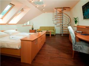 a bedroom with a bed and a desk and a staircase at Heipark Tošovice in Tošovice