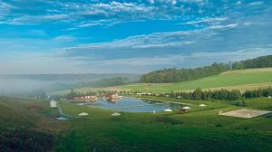 a lake in the middle of a grassy field at Heipark Tošovice in Tošovice