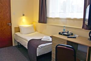 a small room with a bed and a desk at Central Hotel Golders Green in London