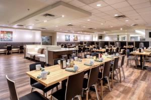 una sala da pranzo con tavoli e sedie in legno di Holiday Inn & Suites Atlanta Airport North, an IHG Hotel ad Atlanta