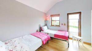 1 dormitorio con 2 camas y ventana en Flatfield ClockTower Coaching Cottages self - Catering B & B, en Hillsborough