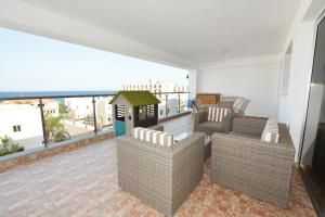 a living room with chairs and a balcony at Seafront Protaras Apartments in Protaras