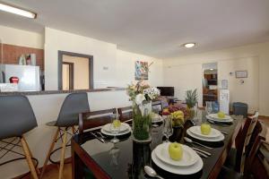 Seafront Protaras Apartments في بروتاراس: غرفة معيشة مع طاولة طعام مع كراسي