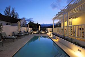 ein Schwimmbad vor einem Haus in der Nacht in der Unterkunft Chapter House Boutique Hotel by The Living Journey Collection in Franschhoek