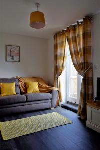 sala de estar con sofá y ventana en Woodlands View en Halesworth
