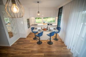 a kitchen with three blue chairs and a table at Apartament w Cieplicach 4 Komfort in Jelenia Góra