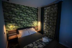 a bedroom with a bed with a green wallpaper at Apartament w Cieplicach Comfort in Jelenia Góra