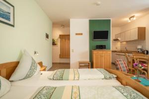 two beds in a room with a kitchen at Ferienwohnung Risthof 2 in Owingen