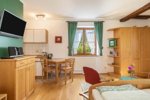 a room with a kitchen and a table with chairs at Ferienwohnung Risthof 2 in Owingen