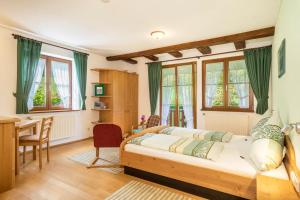 a bedroom with a bed and a desk and a table at Ferienwohnung Risthof 2 in Owingen