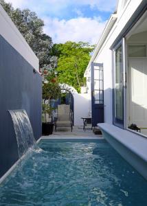 una piscina con cascata in una casa di Chapter House Boutique Hotel by The Living Journey Collection a Franschhoek