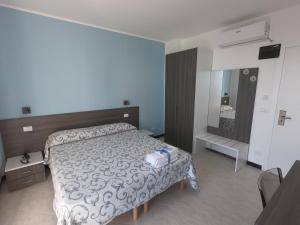 a bedroom with a large bed and a mirror at Hotel Aurora in Varazze