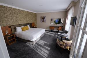 pokój hotelowy z łóżkiem, stołem i krzesłami w obiekcie Midleton Park Hotel w mieście Midleton