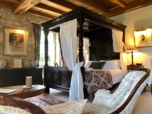 sypialnia z łóżkiem z baldachimem i stołem w obiekcie Domaine des Monges w mieście Saint-Seurin-de-Prats