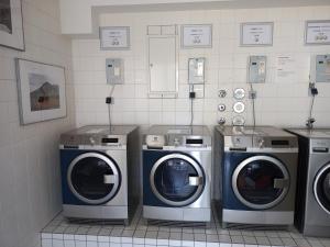 a laundry room with three washers and three machines at Gästehaus des GOETHE-Institut Freiburg in Freiburg im Breisgau