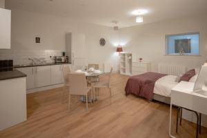 Cet appartement comprend une chambre avec un lit et une table ainsi qu'une cuisine. dans l'établissement Apartment 2, Isabella House, Aparthotel, By RentMyHouse, à Hereford