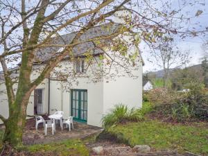 a white house with a table and chairs in front of it at Stone Cottage Kenmare by Trident Holiday Homes in Kenmare