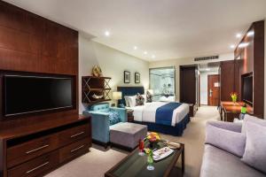 a hotel room with a bed and a television at Alreem Village Hotel in Al Jubail