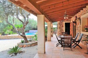 a patio with a table and chairs and a pool at Finca Sa Rota de Son Ramon 132 by Mallorca Charme in Llubí