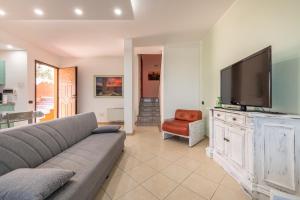 sala de estar con sofá y TV de pantalla plana en Villa Sunset, en Capitana
