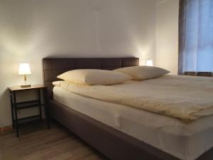 1 dormitorio con 1 cama con 2 almohadas y mesa en Ferienwohnung Wildbad Süd en Bad Wildbad