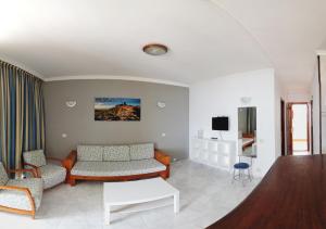 a living room with a couch and a table at Apartamentos Montemar in Playa del Ingles