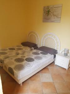 a bed in a room with two white chairs at Le Pin Doré in Antibes