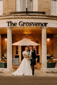 a bride and groom standing in front of the greenhouse at The Grosvenor Stockbridge in Stockbridge