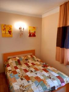 1 dormitorio con 1 cama con edredón en "В центре города" Квартира - "Downtown" Apartment en Almaty