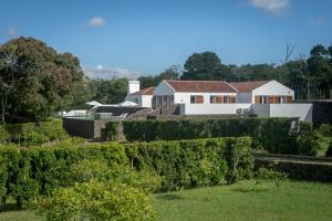 uma vista para a casa a partir do jardim em Quinta dos 10 em Ponta Delgada