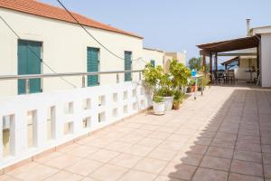 a balcony with plants and a white fence at Casa Galini - 25m from Beach Deluxe Apartment in Kalyves