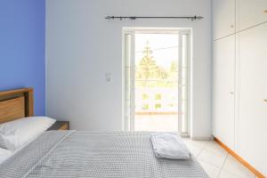 a bedroom with a bed and an open door at Casa Galini - 25m from Beach Deluxe Apartment in Kalyves