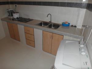 a small kitchen with a sink and a toilet at Malinja Home 3 in Pantai Cenang