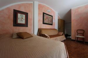 a bedroom with a bed and a chair in it at Villa Azzurra - Genova Resort Accomodations in Genoa